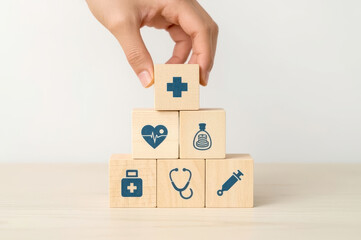 Health Insurance Concept, Hand arranging wood cube stacking with icon healthcare medical on wood background, financial concept
