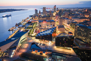 Aerial image of Liverpool skyline illuminated by the lights of the evening with a large ferry...