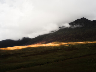 View of carrauntoohill mountain in ireland during daytime with clouds blanketing the summit area of the rugged landscape.