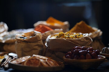 Colorful selection of dried herbs, spices, and natural ingredients in paper bags on rustic market...
