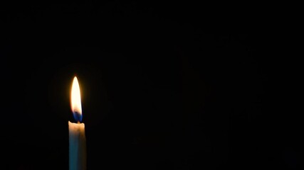 burning candle on black background in one side of the frame - Powered by Adobe
