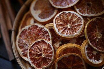 Close-up of dried orange slices in bamboo basket. Natural citrus fruit preserved for herbal tea,...