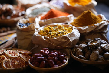 Colorful selection of dried herbs, spices, and natural ingredients in paper bags on rustic market...