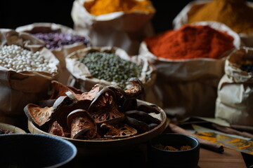 Colorful selection of dried herbs, spices, and natural ingredients in paper bags on rustic market...