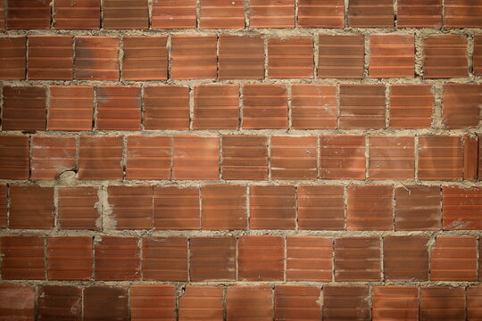 Parede de casa de tijolos vermelhos, sem reboco, de casa brasileira ainda em constru&ccedil;&atilde;o. Parede de alvenaria comum