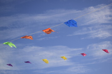 Bandeirinha de festa junina estendidas sobre seu azul cheio de pequenas nuvens
