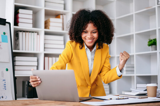 Businesswoman Celebrating Success at Office Desk With Laptop Computer Happy Young Professional Achievement For Online Business