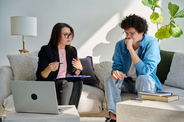 Mental therapy session, young guy talking with female psychologist, in office