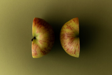 Two Sliced Apple Halves on a solid color backdrop.