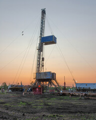 Drilling a well in an oil field. Mobile drilling rig and drilling equipment. Summer. Beautiful sky and nature.