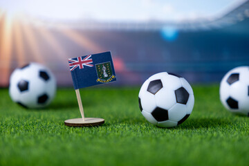 British Virgin Islands flag and soccer balls on green field, representing international football...
