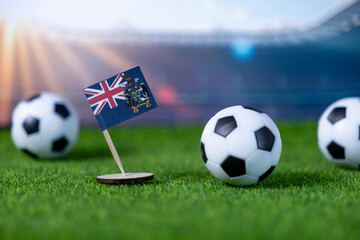Flag of South Georgia and South Sandwich Islands stands prominently on green grass with soccer balls, symbolizing national pride for upcoming international sports