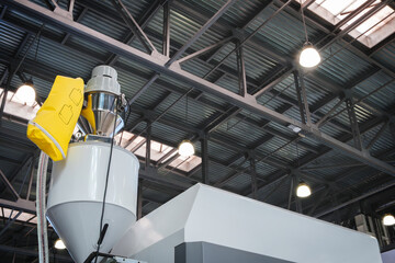 Large industrial PVC extrusion machine against industrial metal roof with lighting