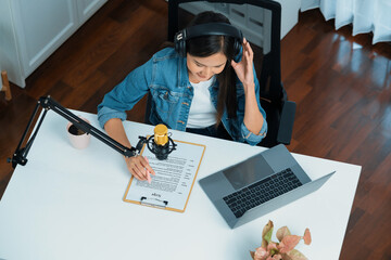 Top view in host channel Asian influencer talking in broadcast online wearing headsets on social...