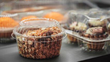 Container of food with nuts and fruit in it. The container is clear and has a lid