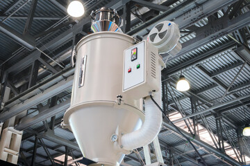 Large industrial PVC extrusion machine against industrial metal roof with lighting.