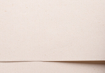Modern background with overlapping sheets of premium beige and cream paper. Soft grainy texture,