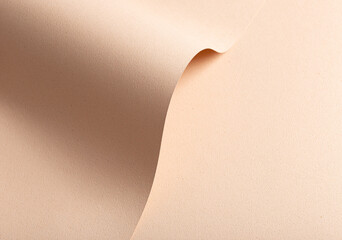 Monochrome background with wavy beige and cream designer paper. Curved folds and perforated shapes,