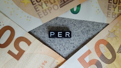 PER acronym made of black letter cubes among Euro banknotes. Plan d’Épargne Retraite (Retirement...