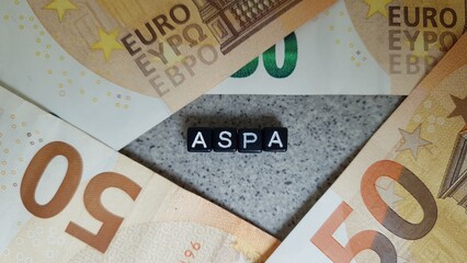 ASPA acronym made of black letter cubes among Euro banknotes. Allocation de Solidarité aux...