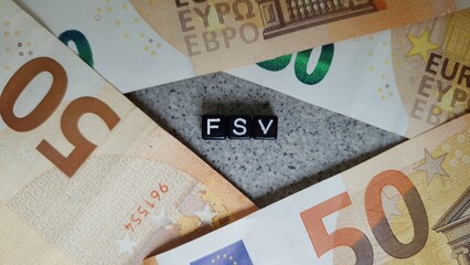 FSV acronym made of black letter cubes among Euro banknotes. Fonds de Solidarité Vieillesse...