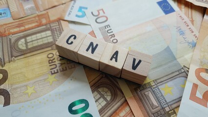 CNAV acronym made of wooden letter cubes on pile of Euro banknotes. Caisse Nationale d’Assurance Vieillesse (National Old-Age Insurance Fund)