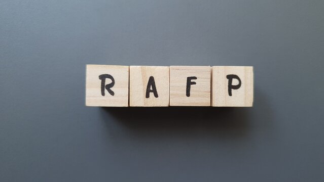 RAFP acronym made of wooden letter cubes on dark background. Retraite Additionnelle de la Fonction Publique (Additional Pension for Public Servants)
