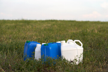 Chemical weeding of the field. Use of herbicides in agriculture. Containers with chemical preparation at the edge of the field after harvesting green fodder.