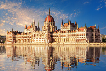 Parliament of Hungary building reflecting in Danube River at sunrise in Budapest