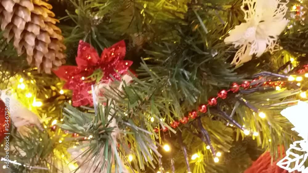 Poster christmas tree with many ornaments including a snowflake and a red ornament. the tree is lit up and 