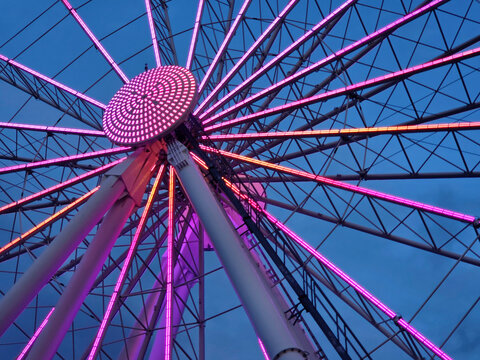 The Seattle Great Wheel - Ferris Wheel Illuminated with Pink and Orange Lights at Dusk