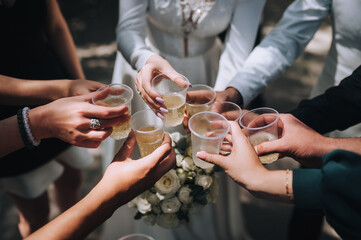 Many people at a party, wedding, celebration hold plastic glasses with champagne. Photography, leisure concept.