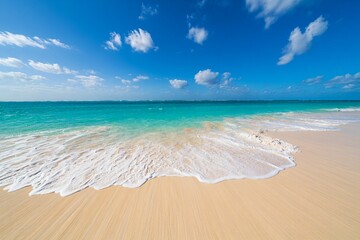 Soft waves on a sandy beach under a blue sky free beach background