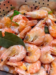 Fresh shrimp boiled with spices rest in a colander