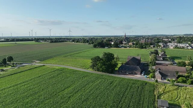 Luftbildaufnahme von Aldekerk bei Kerken mit Bahnhof an einem sonnigen Sommerabend. Weitwinkel-Drohnenflug &uuml;ber D&auml;cher, Felder und Gleisanlagen im warmen Licht der Abendsonne.