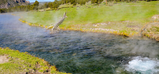 Scenic panoramic landscape view of a spring of boiling water in the geothermal area of the Terrace Springs in Yellowstone National Park. No people.