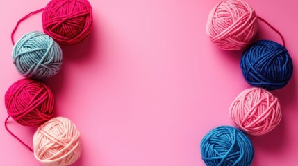 A cheerful flat lay of colorful yarn balls on a soft pink background—perfectly organized to spark creativity and cozy inspiration for any craft lover.