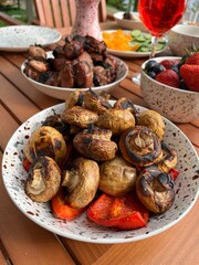 Summer outdoor party arrangement.barbecue Champignons and red pepper,shish kebab,strawberries.outdoor summer picnic at wooden table in garden overlooking the lake.Nature Vacation.Food background