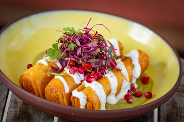 Potato flautas, drizzled with remoulade and topped with micro greens.