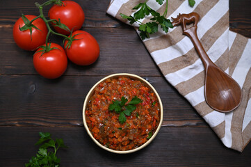 bowl with eggplant and vegetable appetizer on wooden table