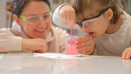 Caucasian Woman and Preschooler Daughter Child Girl Wearing Protective Glasses Having Fun Preparing STEM Science Experiment on Kitchen Table using Education Kit for Homeshooling Learning