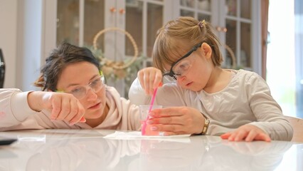 Caucasian Woman and Preschooler Daughter Child Girl Wearing Protective Glasses Having Fun Preparing STEM Science Experiment on Kitchen Table using Education Kit for Homeshooling Learning