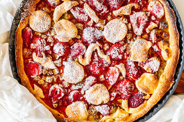Rhubarb and strawberry tart with mint and sugar. Background with pie texture. Close-up, top view.