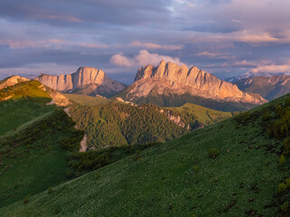 View of majestic sheer cliff in the sunset light. Mount Chertovy Vorota at sunset, drone shot