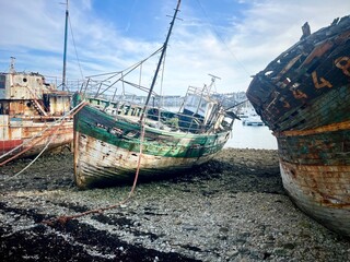 Épave rouillée d’un vieux bateau de pêche sur un port breton