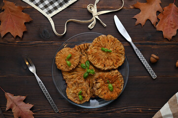 plate with fried mushrooms on wooden table, flat lay