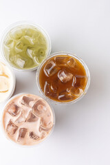 Thai ice tea in plastic cup on white background, top view