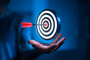 Illuminating Success A Focused Arrow Hits the Bullseye on a Glowing Target Held in Hand Symbolizing Precision Achievement and Strategic Business Goals in Blue Ambience