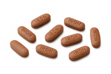 Iron tablets scattered on a transparent background, emphasizing the importance of iron supplementation for health