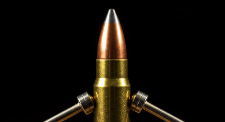 A close up shot of a bullet with metal rods attached against a stark black studio background view